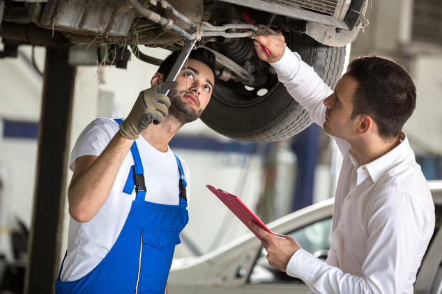 Unterseite Auto mit Mechaniker in Werkstatt